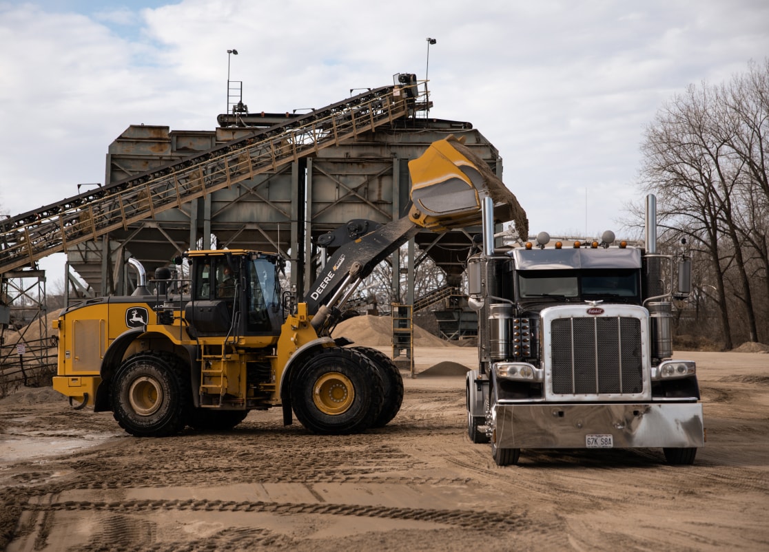 Loader dumping fine aggregate into haul truck in Missouri