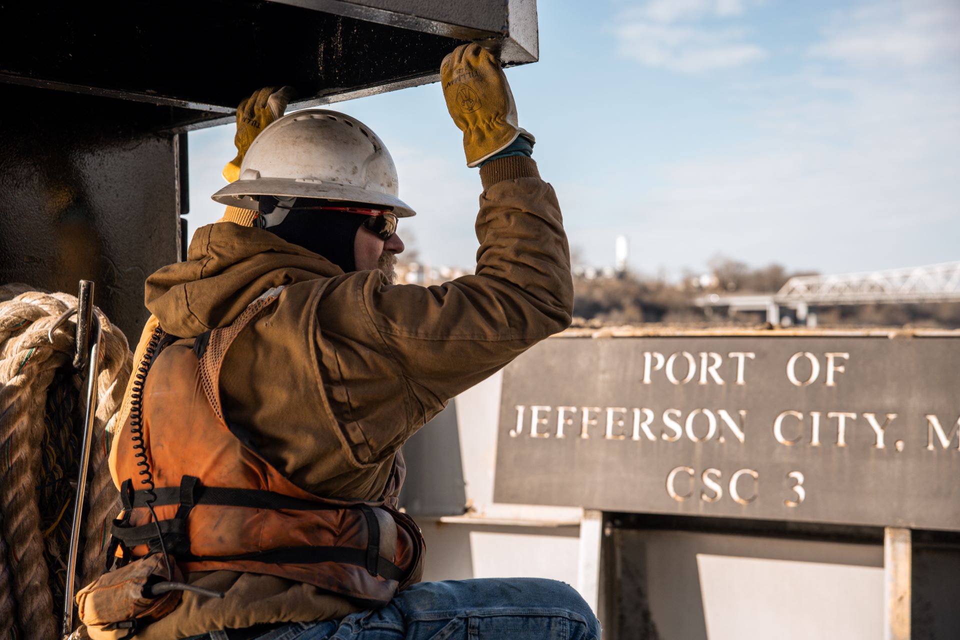 Capital worker in front of Port of Jefferson City sign